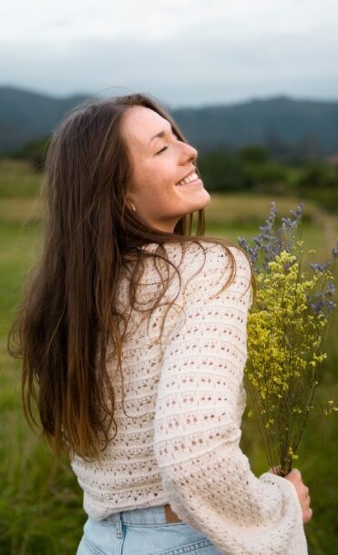 side-view-smiley-woman-holding-flowers (1)